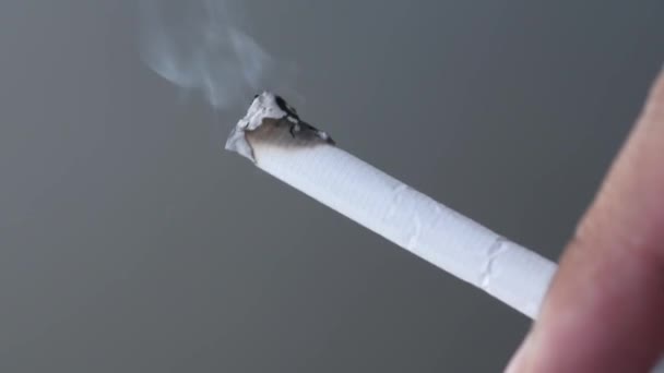 De cerca sosteniendo un cigarrillo en llamas sobre fondo negro — Vídeos de Stock