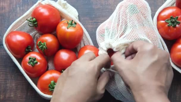 Tomates frescos en una bolsa de compras reutilizable en la mesa — Vídeos de Stock