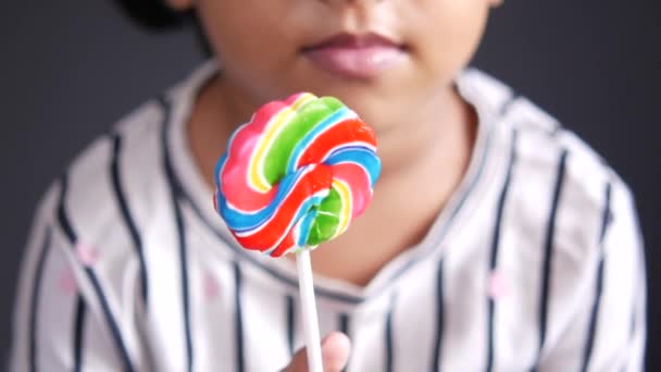 Niña sosteniendo un caramelo de piruleta — Vídeo de stock