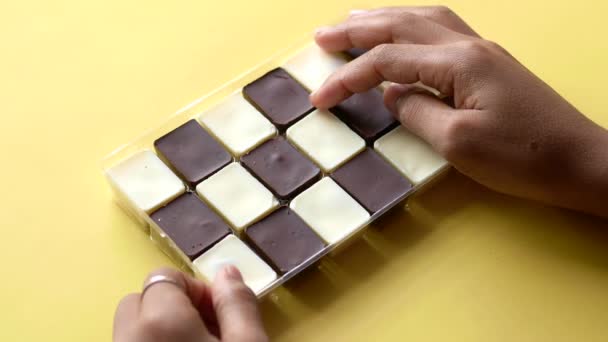 Segurando uma caixa de chocolate escuro e branco — Vídeo de Stock