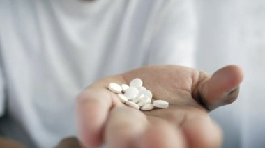 İlaç kutusundan dökülen ilaçlı adam eli. 