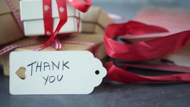 Thank you note and gift box on black background — Stock Video