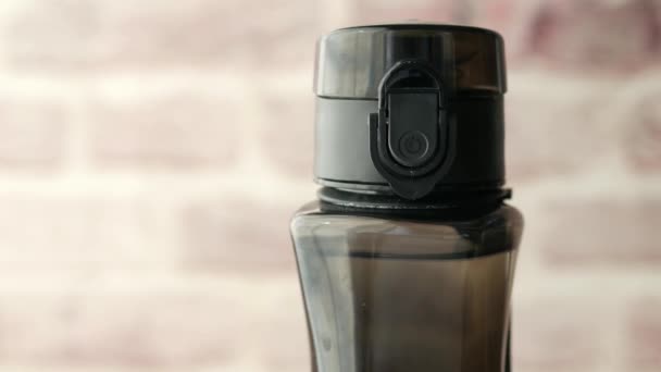 Open een dop van een herbruikbaar vers drinkwater in een plastic recipiënt — Stockvideo