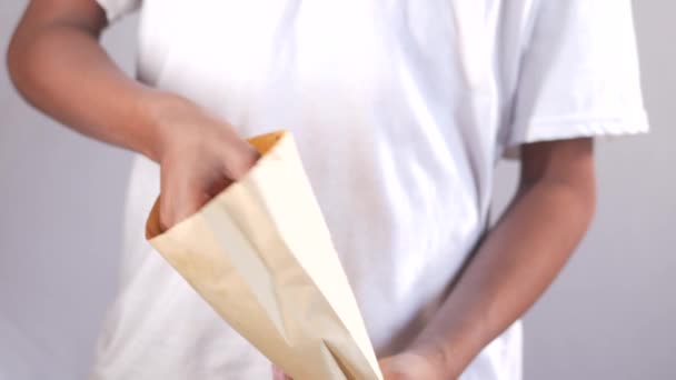 Jovem tirando donuts de um pacote — Vídeo de Stock