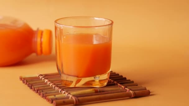 오렌지 주스에 색 배경 유리를 입힌 모습 — 비디오