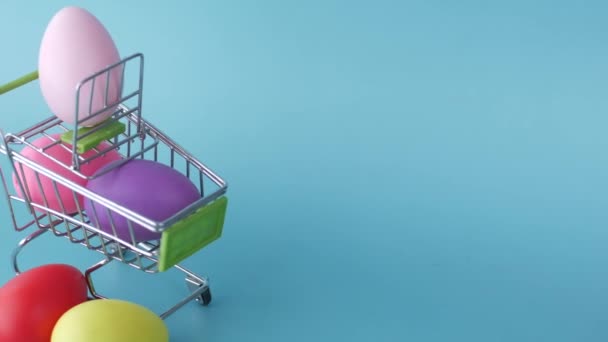 Пасхальная концепция с многоцветным яйцом с шоппинг-артом на цветном фоне — стоковое видео