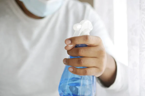 Mano en guantes de goma azul que sostiene la botella del aerosol con espacio de copia —  Fotos de Stock