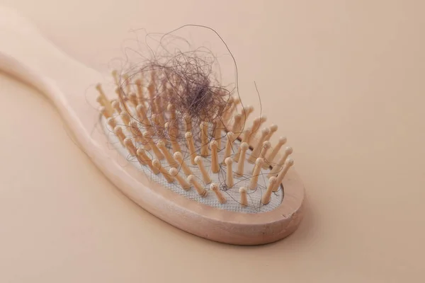 Расческа с потерянными волосами на столе — стоковое фото