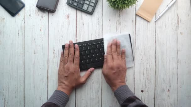 Ovanifrån av person hand rengöring ett tangentbord på bordet — Stockvideo