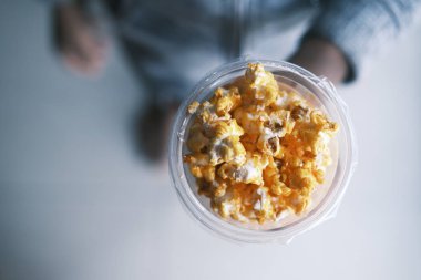 Genç adam patlamış mısır yiyor. 