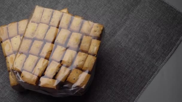 Πάνω όψη γλυκών μπισκότων σε πλαστικό πακέτο σε ξύλινο τραπέζι — Αρχείο Βίντεο