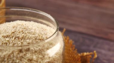  Psilyum tohumları masanın üzerinde cam bir kabın içinde 