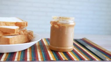 Fıstık ezmesi ve ekmek yığını masada. 