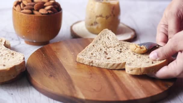 아몬드 버터를 식탁 위에 펼쳐 놓은 갈색 빵 — 비디오