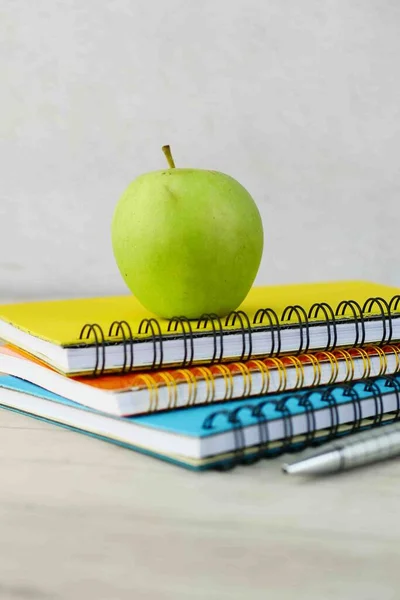 Concept noir à l'école avec pomme sur bloc-notes sur la table. — Photo