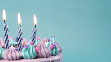 Açık yeşil arka planda doğum günü pastasında mum yakmak 