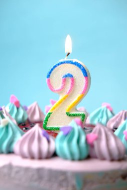 Açık yeşil arka planda doğum günü pastasında mum yakmanın yavaş çekimi 