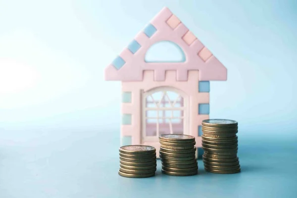 Pila de monedas y casa en la mesa, el concepto de financiación de la casa —  Fotos de Stock
