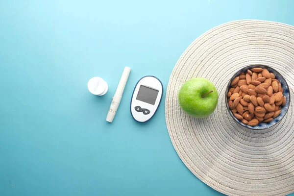 糖尿病测量工具，杏仁和苹果放在桌上 — 图库照片