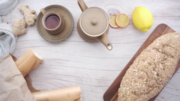 Κορυφαία άποψη του πράσινου τσαγιού και ψημένου ψωμιού στο τραπέζι — Αρχείο Βίντεο