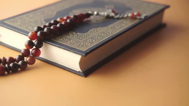 Holy book Quran and rosary on table, close up. — Stock Video