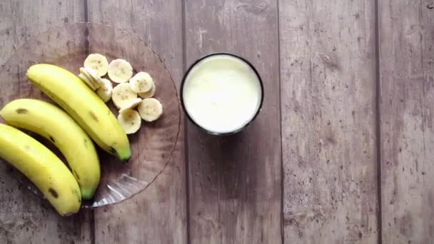 Vue de dessus de tranche de verre de banane de lait sur la table — Video