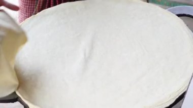 Sokakta büyük şapkalar yapıyor. 