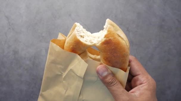Pan de bagel fresco en un papel sobre la mesa — Vídeos de Stock