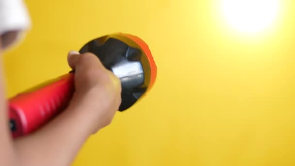 Hand holding a tourch light against yellow background, — Stock Video