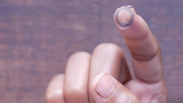 A kontaktlencse közelsége az ujjon . — Stock videók