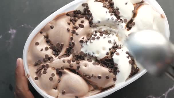 Mano recogiendo helado con una cuchara de un tazón — Vídeo de stock