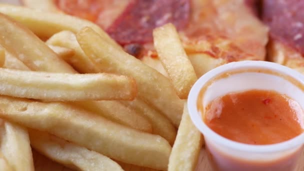 Papas fritas, pizza y salsa en un plato — Vídeo de stock