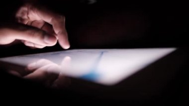 Adam el ile ofis masasında dijital tablet üzerinde çalışıyor, kendi yarattığı grafiği kullanarak. 