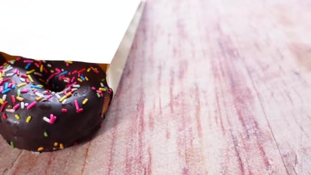 Chocolate donuts in a packet on table — Stock Video
