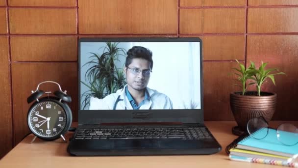 Młody azjatycki lekarz na ekranie laptopa w wideo czat. — Wideo stockowe