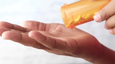 İlaç kutusundan dökülen ilaçlı adam eli. 