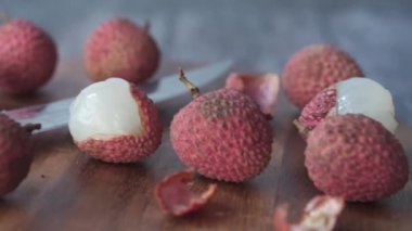 Masanın üzerinde bir Lychee 'nin derisini yüzüyor. 