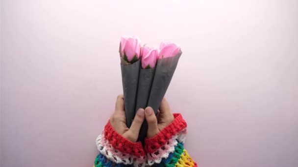 Женщины держат в руках розовый цветок — стоковое видео
