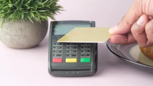 Contactloos betalingsconcept met jonge man die met een creditcard betaalt — Stockvideo