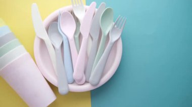 Masada renkli plastik tabaklar, cam ve çatal bıçak takımı 