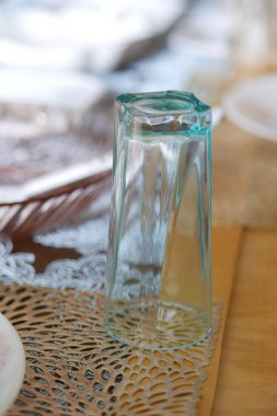 Masasında tabak olan boş bir içki bardağı. 