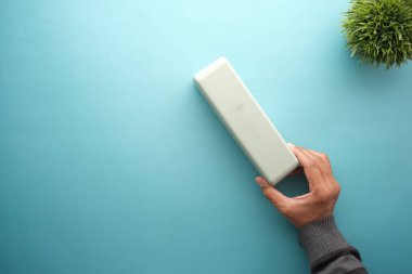 Erkek eli masada akıllı hoparlör kullanıyor. 