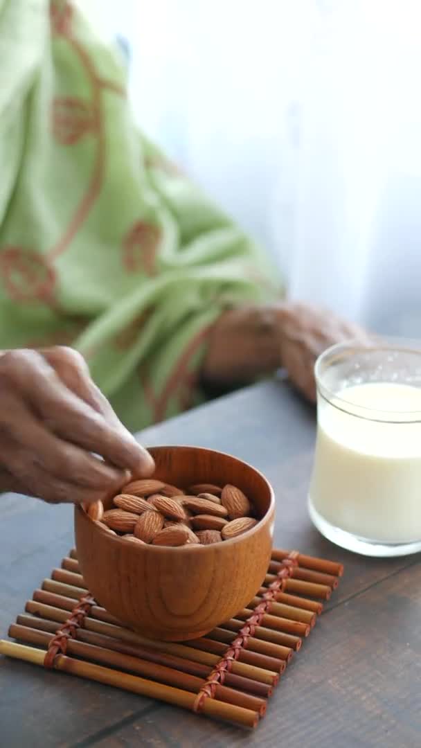 Закрыть руки пожилым женщинам, держащим миску с миндалем — стоковое видео