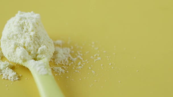 Κοντινό πλάνο του βρεφικού γάλακτος σε σκόνη και κουτάλι στο φόντο πλακιδίων. — Αρχείο Βίντεο