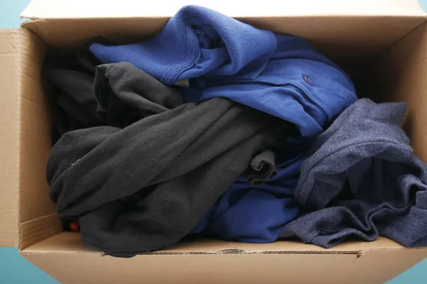 Donation box with donation clothes on a wooden table .