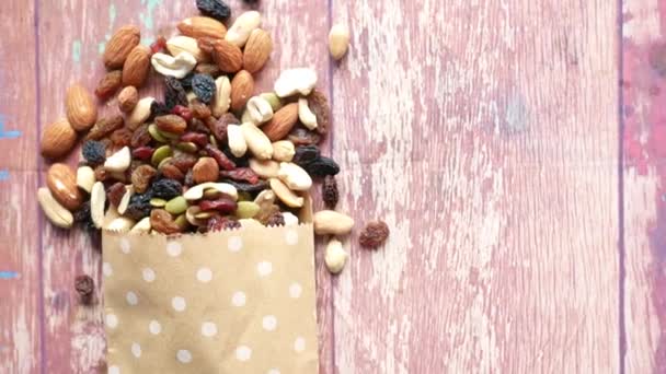 Primer plano de muchas nueces mezcladas derramándose de una bolsa de papel — Vídeos de Stock