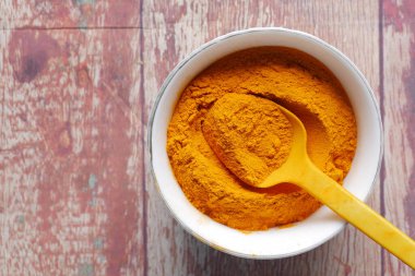 Masadaki kabın içindeki zerdeçal kökü tozunun üst görüntüsü ,