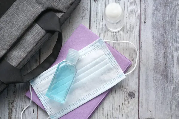 Cerrahi maskeler ve turuncu arka planda el dezenfektanı. 