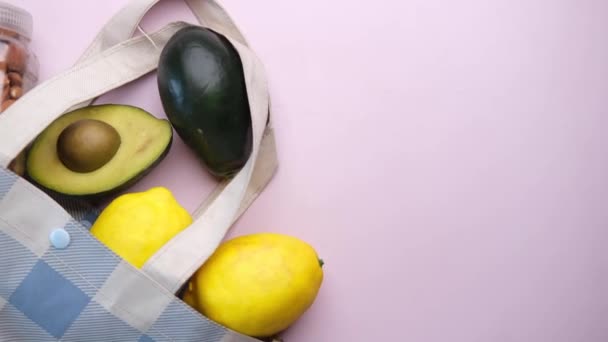 Noce di mandorla, lime e avocado in una borsa della spesa sul tavolo — Video Stock