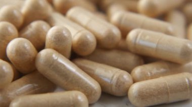 Bitkisel ilaç kapsülü masaya dökülüyor. 